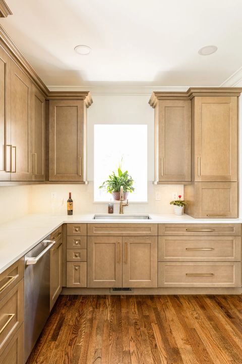 Greenville kitchen with light brown wood cabinetry, brass bar pull handles, white countertops, subway tile backsplash, double-basin sink with gold faucet by Tekton Builds.